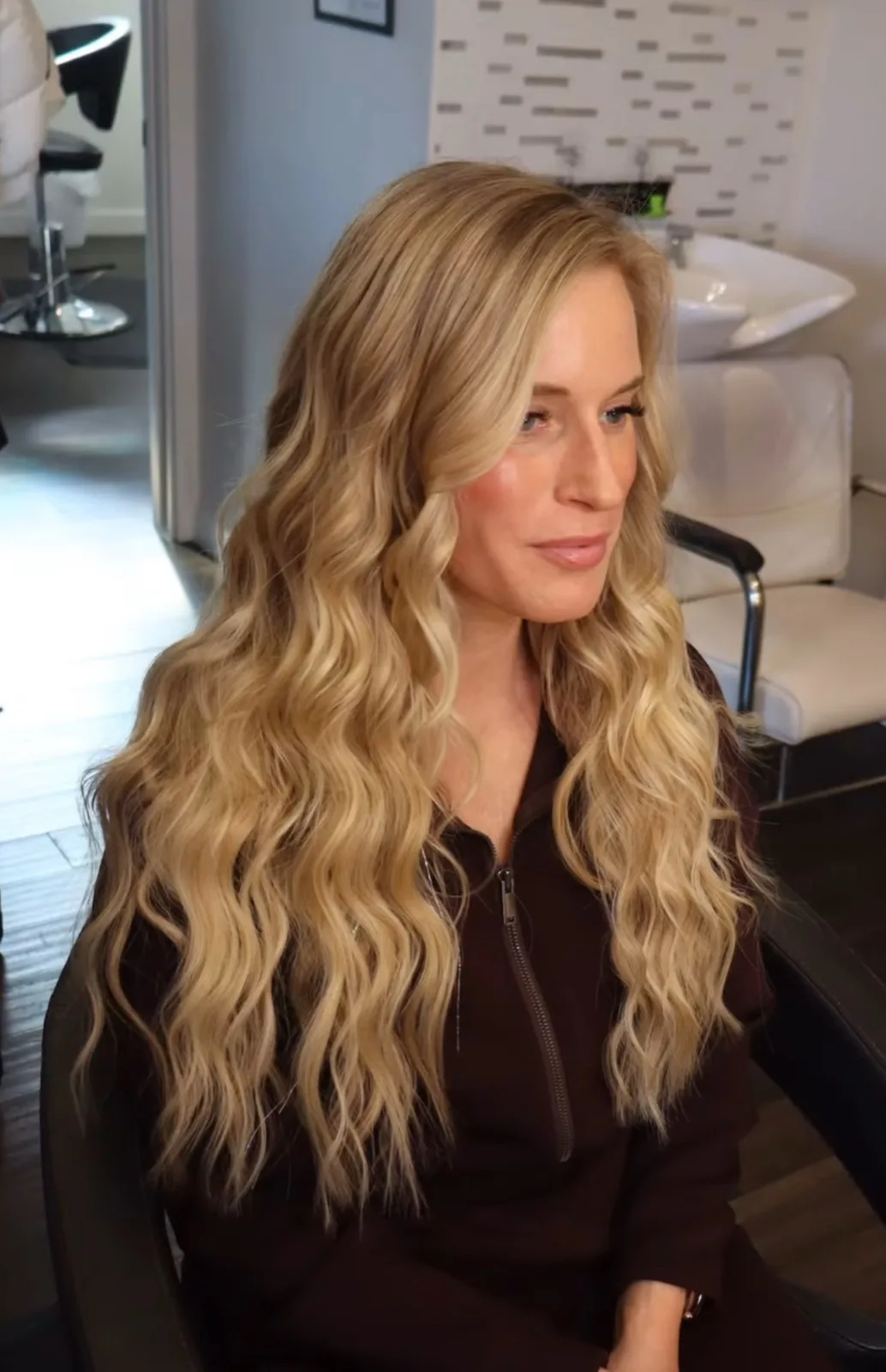 Blonde hand tied extensions styled in soft waves