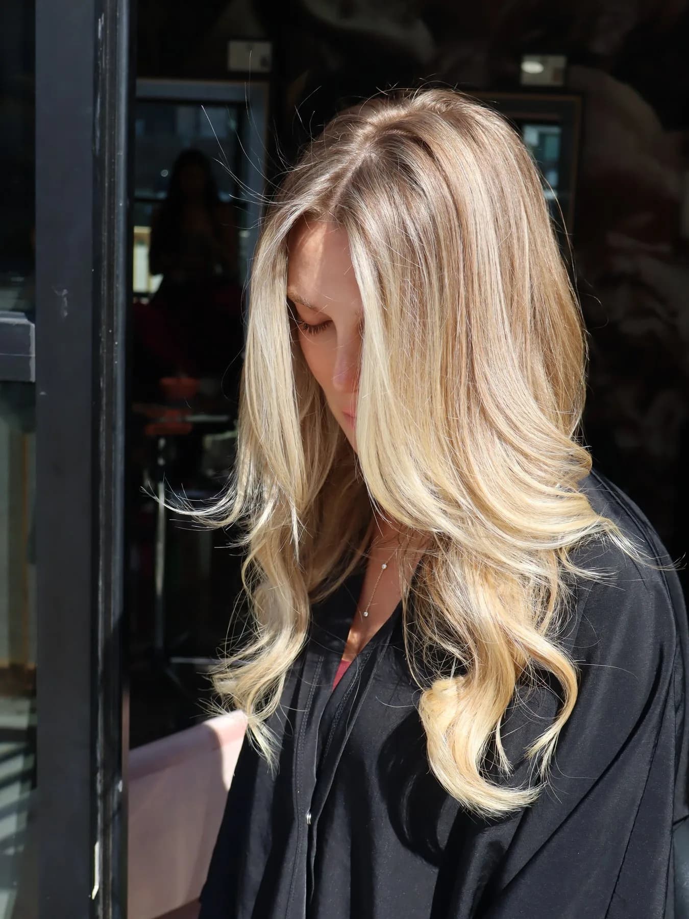 Golden blonde layered extensions catching the sunlight
